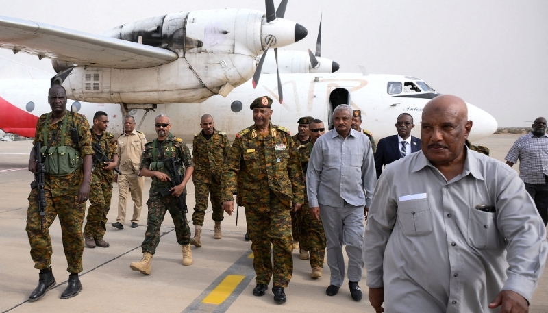 Le général Abdel Fattah al-Burhan (au centre) arrive à l'aéroport militaire de Port-Soudan entouré de ses gardes et d'autres officiels, le 27 août 2023.