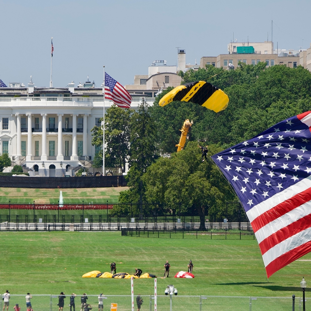 Des parachutistes de l'armée américaine atterrissent avec un drapeau américain géant près de la Maison Blanche, à Washington, le 4 juillet 2026.