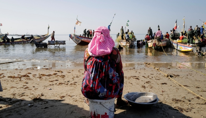Une marchande de poisson attend le retour des pêcheurs dans le port de Joal, en 2020.