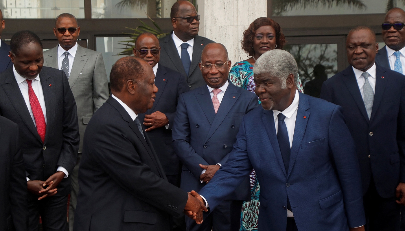 Alassane Ouattara serre la main du nouveau premier ministre, Robert Beugré Mambé, lors du premier conseil des ministres du nouveau gouvernement, le 18 octobre 2023.
