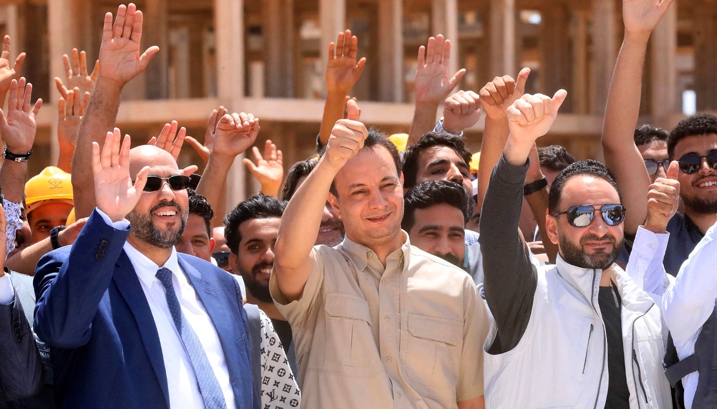 Belkacem Haftar (centre), responsable du fonds de reconstruction de l'est de la Libye, avec ses assistants lors de l'inspection d'un projet de construction de 20 000 logements, dans la ville de Benghazi, le 18 mai 2025.