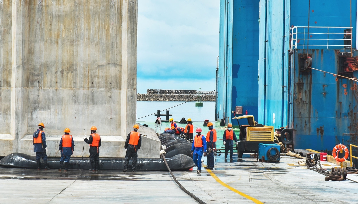 Techniciens travaillant à l'installation du premier caisson de la phase II de la construction du port en eau profonde de Kribi, au Cameroun, en octobre 2022.