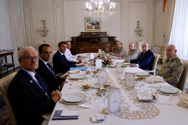 Le déjeuner, le 26 août, à Alger, du président français Emmanuel Macron avec Abdelmadjid Tebboune. De gauche à droite : Bernard Emié (DGSE), le ministre des armées Sébastien Lecornu, Emmanuel Macron et le chef d'état-major Thierry Burkhard. Côté algérien, Mehenna Djebbar est à la gauche du président Tebboune, Saïd Chengriha à sa droite.