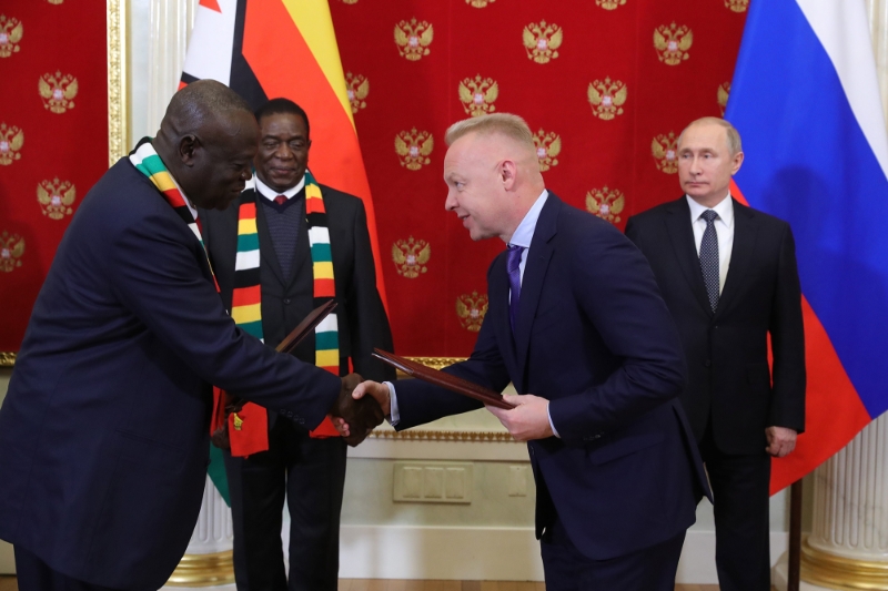 Le président russe Vladimir Poutine (à l'arrière à droite) et son homologue zimbabwéen Emmerson Mnangagwa (à l'arrière à gauche) assistent à l'échange de documents entre Dmitry Mazepin (à l'avant à droite), président d'Uralchem, et Perence Shiri (à l'avant à gauche), ministre zimbabwéen de l'agriculture, le 15 janvier 2019 à Moscou.