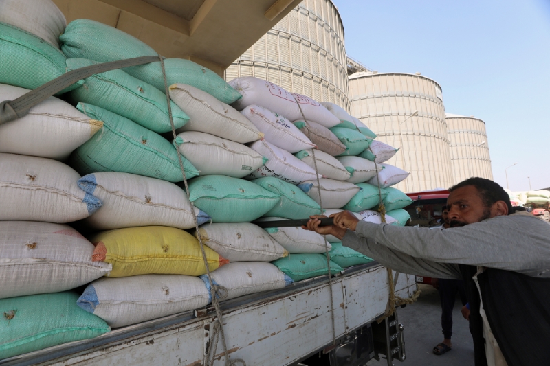 Des ouvriers collectent le blé dans les silos à grains de Banha, dans le gouvernorat de Qalyubia, en Egypte, le 25 mai 2022.