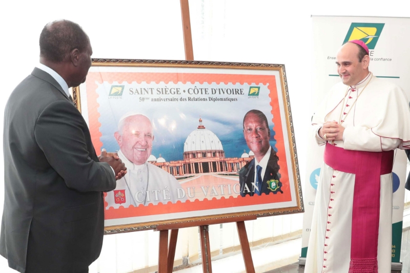 Alassane Ouattara et le nonce apostolique Paolo Borgia lors de la cérémonie de dévoilement du timbre commémoratif du 50e anniversaire de l'établissement des relations diplomatiques entre la Côte d'Ivoire et le Vatican.