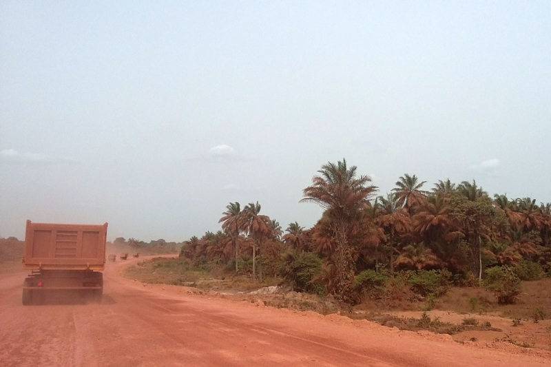 Le passage des camions transportant de la bauxite génère des poussières rouges et toxiques, ici aux alentours de Boké.